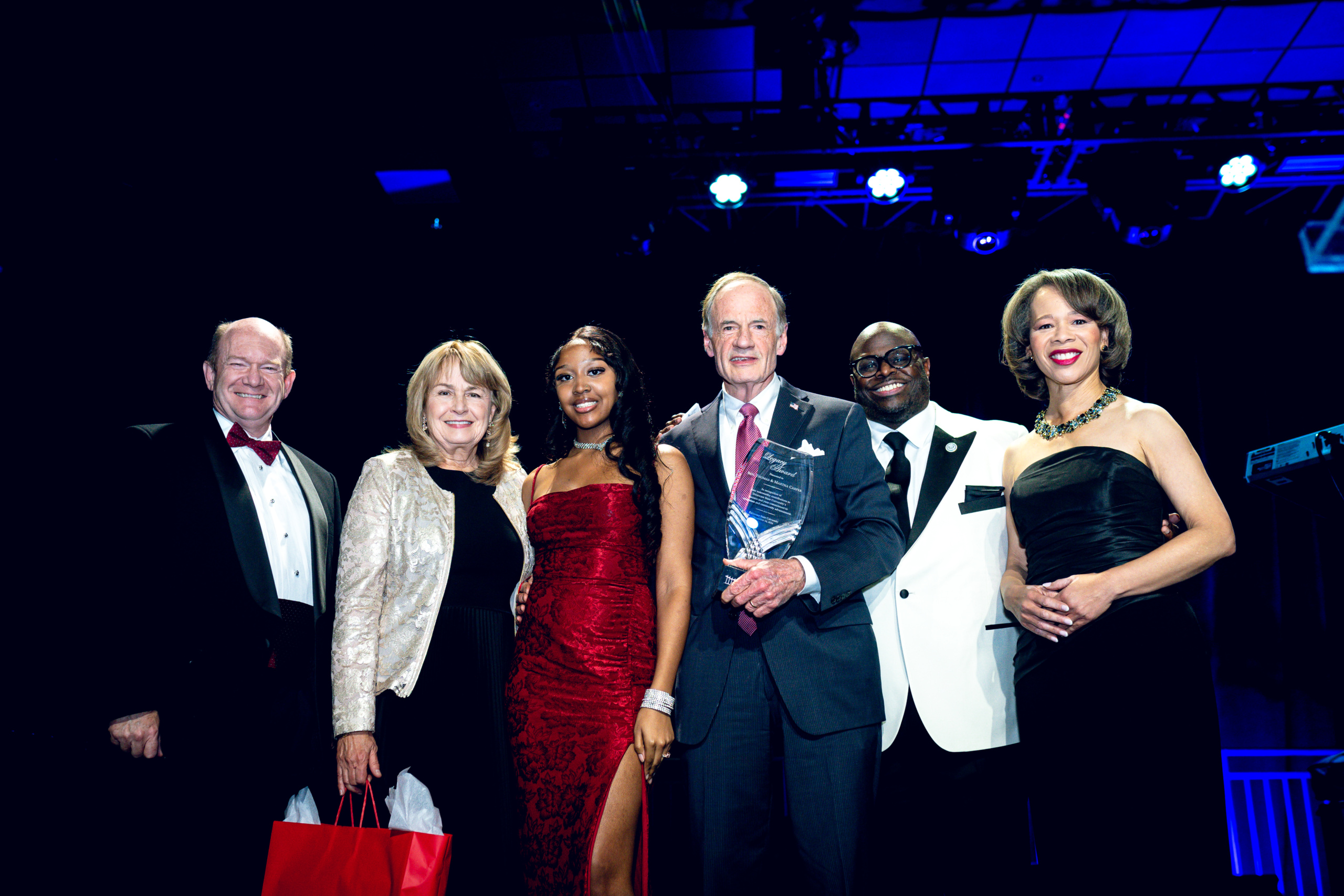 (L-R) U.S. Sen. Chris Coons, Martha Carper, DSU student Jahmyah Robertson, U.S. Sen. Tom Carper, DSU President Tony Allen, and incoming U.S. Sen. Lisa Blunt Rochester pose on stage at the Scholarship Ball after Carper was honored with Delaware State University’s inaugural UBUNTU Legacy Award. Photo submitted.